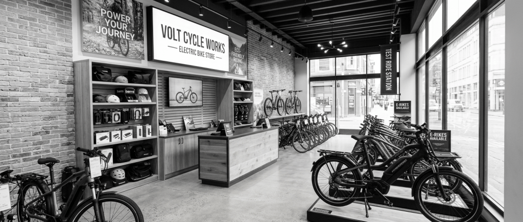 Electric bikes displayed inside Volt Cycle Works store with customers browsing